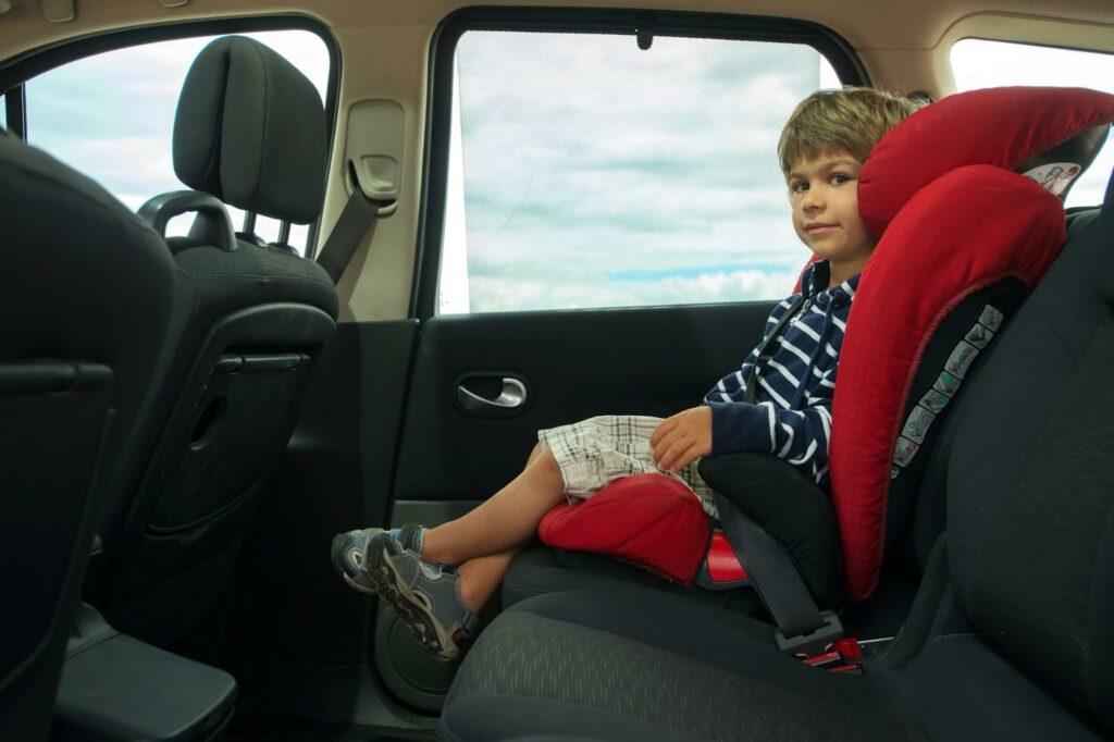 Child sits in booster seat.