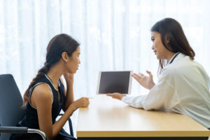 A patient and physician discussing delayed symptoms in an office consultation after a car accident.