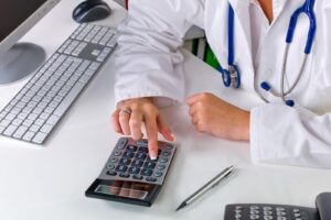 Doctor calculates medical bills after an accident.