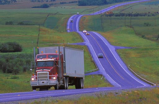 A semi-truck pulling a trailer on the highway. How much does a semi-truck weigh?