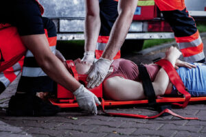 Paramedics immobilizing a patient with a potential spinal cord injury at the scene of an accident; serious personal injury case.