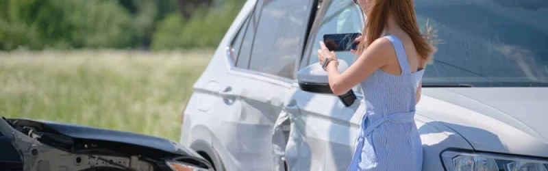 Driver taking a picture of a car after an accident and gathering evidence