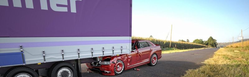 Image of auto being dragged under semi-truck; trucking accident.