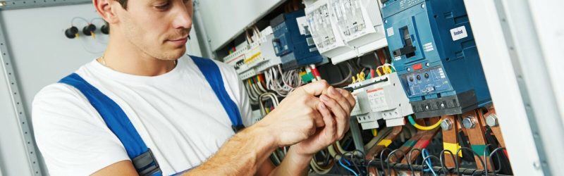 Young male electrician working on complex wiring.