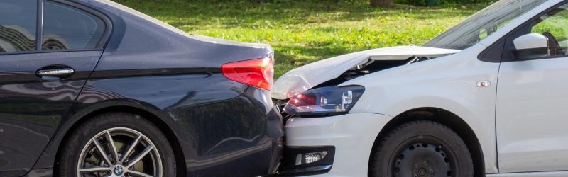 The aftermath of a rear-end car accident with damage to both vehicles.