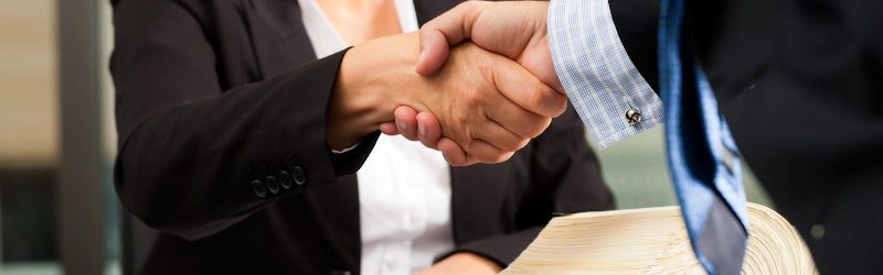 An attorney shaking hands with an insurance adjuster.